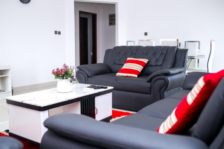 Salon lumineux avec canapés cuir noir et table marbre